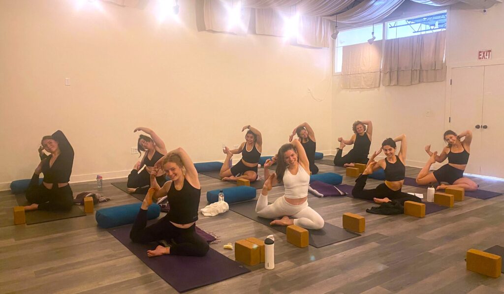 A group of people enjoying yoga in the SYC studio.
